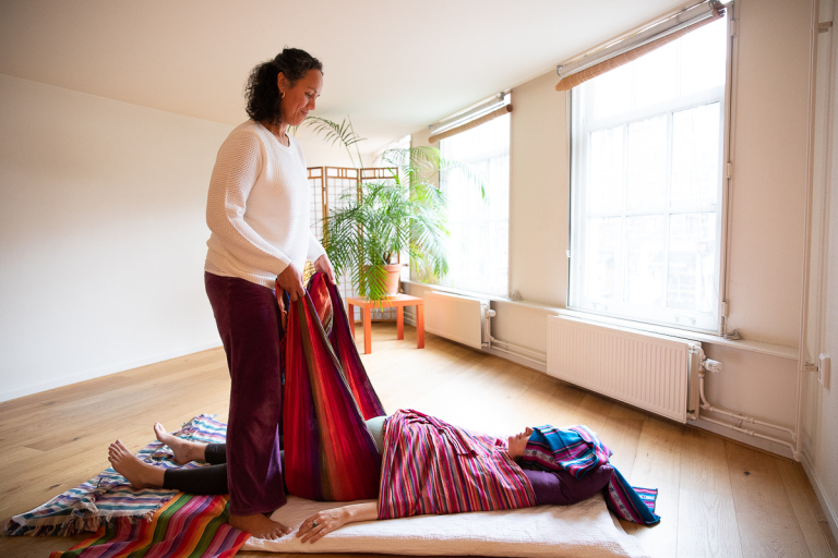 Amber geeft een vrouw een rebozo massage